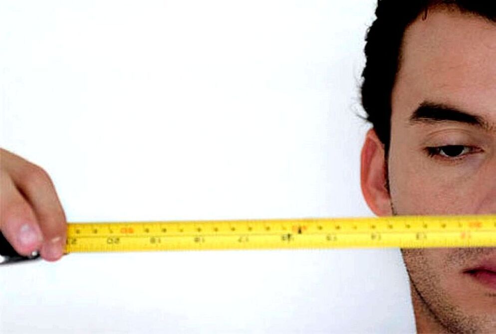 seorang lelaki dengan pembaris mengukur zakar sebelum membesar